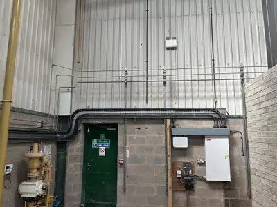 Part of the new pipework infrastructure installed at the Tamworth facility. This section shows three stacked pipework runs routed through the building &mdash; two high-pressure lines supplying the wash bay and one low-pressure feed serving the pressure washin